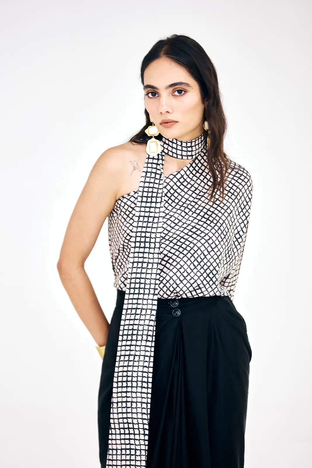 Abstract striped one-shoulder top paired with flowing black skirt